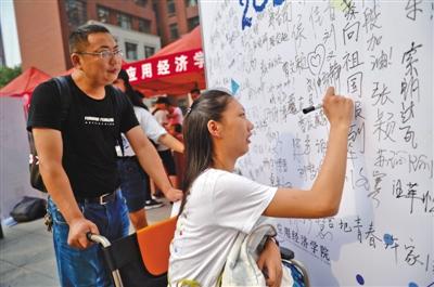 新生在簽名板前簽名留念。